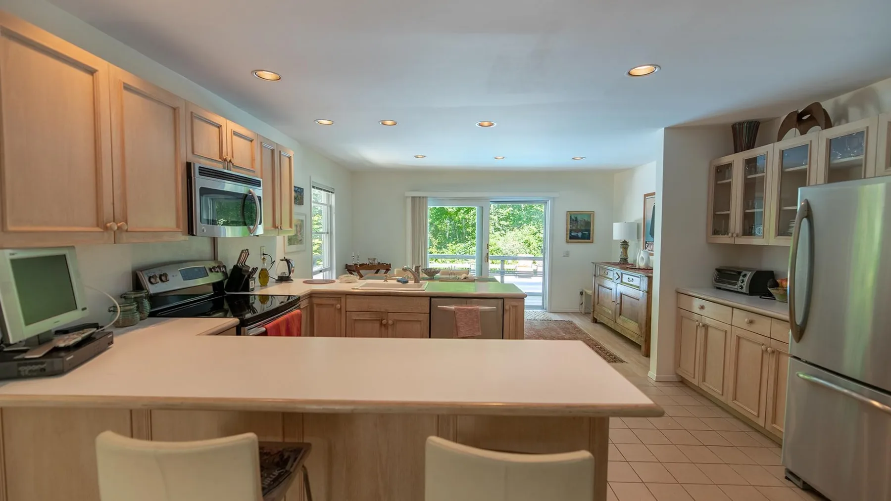 A kitchen with a broad central counter and cabinets along the walls.