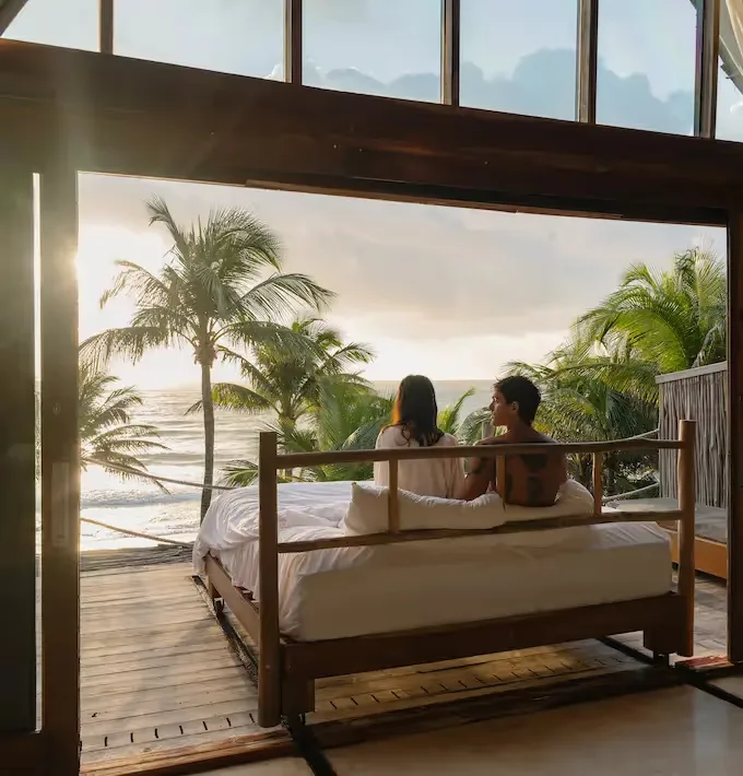 Hotel suite with a sliding bed opening toward a beach-facing terrace.