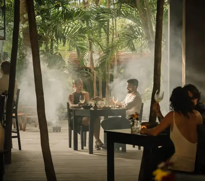Outdoor dining area surrounded by tropical greenery.