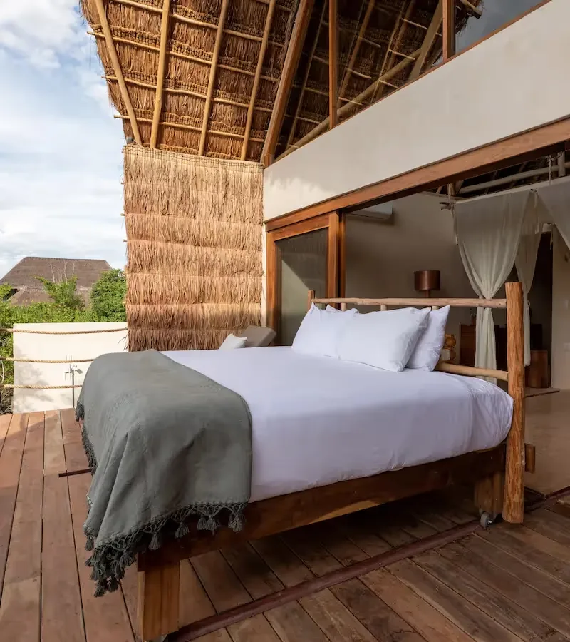 Suite terrace with an outdoor bed and wooden architecture.