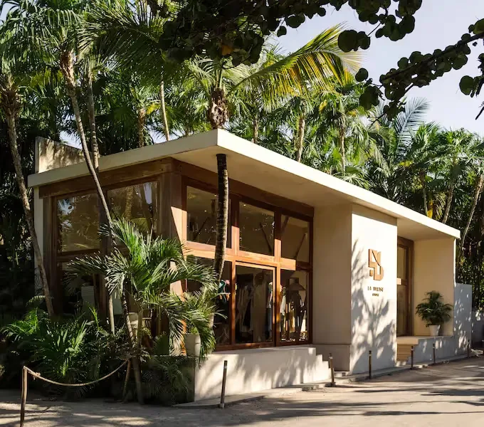 Hotel boutique exterior surrounded by tropical greenery.