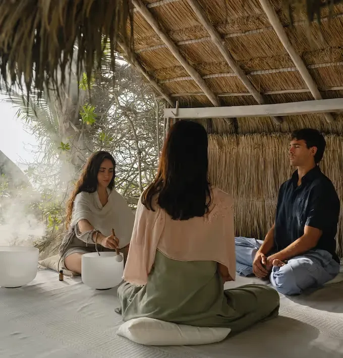 Wellness session beneath a palapa.