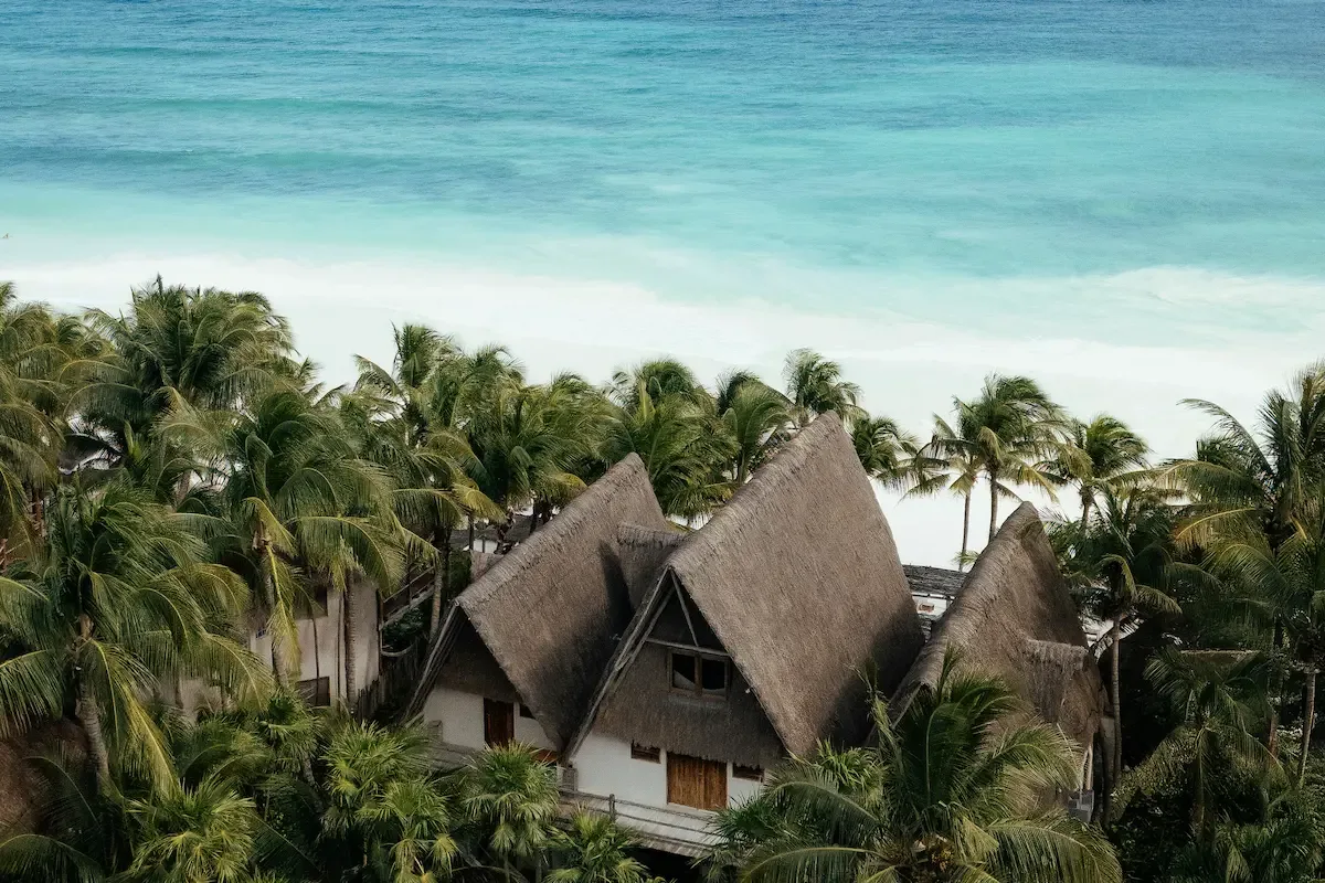 Aerial view of the hotel’s thatched roofs beside the Caribbean Sea.