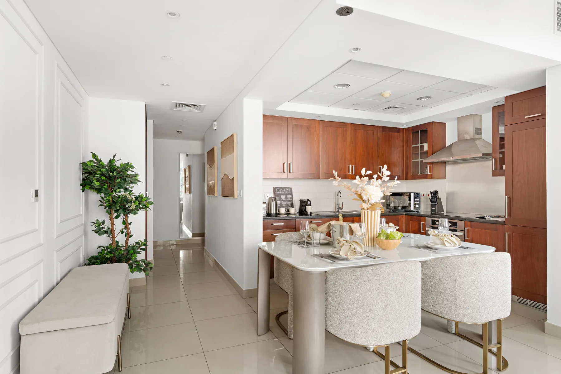 Una cocina luminosa con comedor, isla central y asientos tapizados.