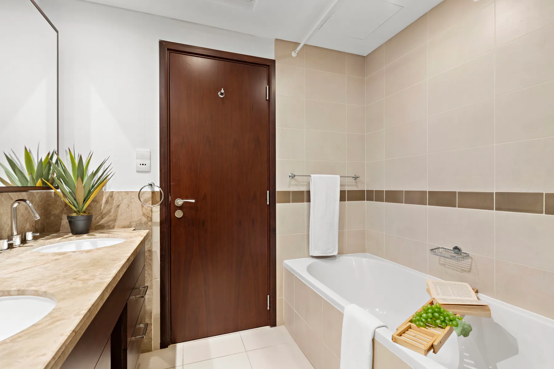 Un baño alicatado con bañera, toalla y lavabo.