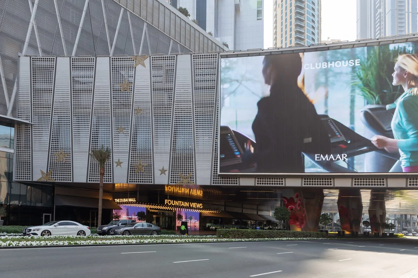 La fachada de un edificio moderno con una gran pantalla digital sobre la calle.