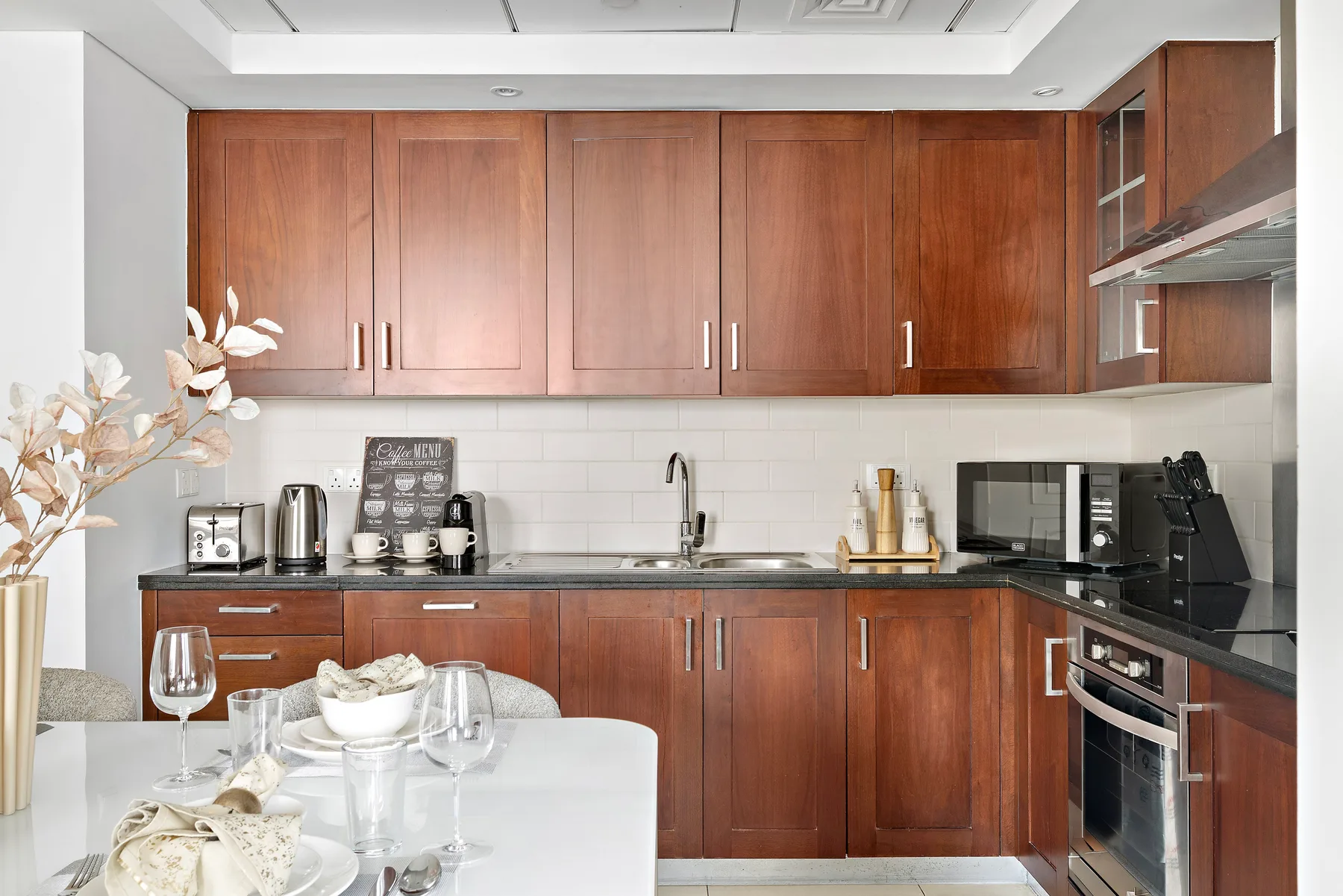 Una cocina moderna con gabinetes de madera, electrodomésticos de acero inoxidable y una mesa de comedor.