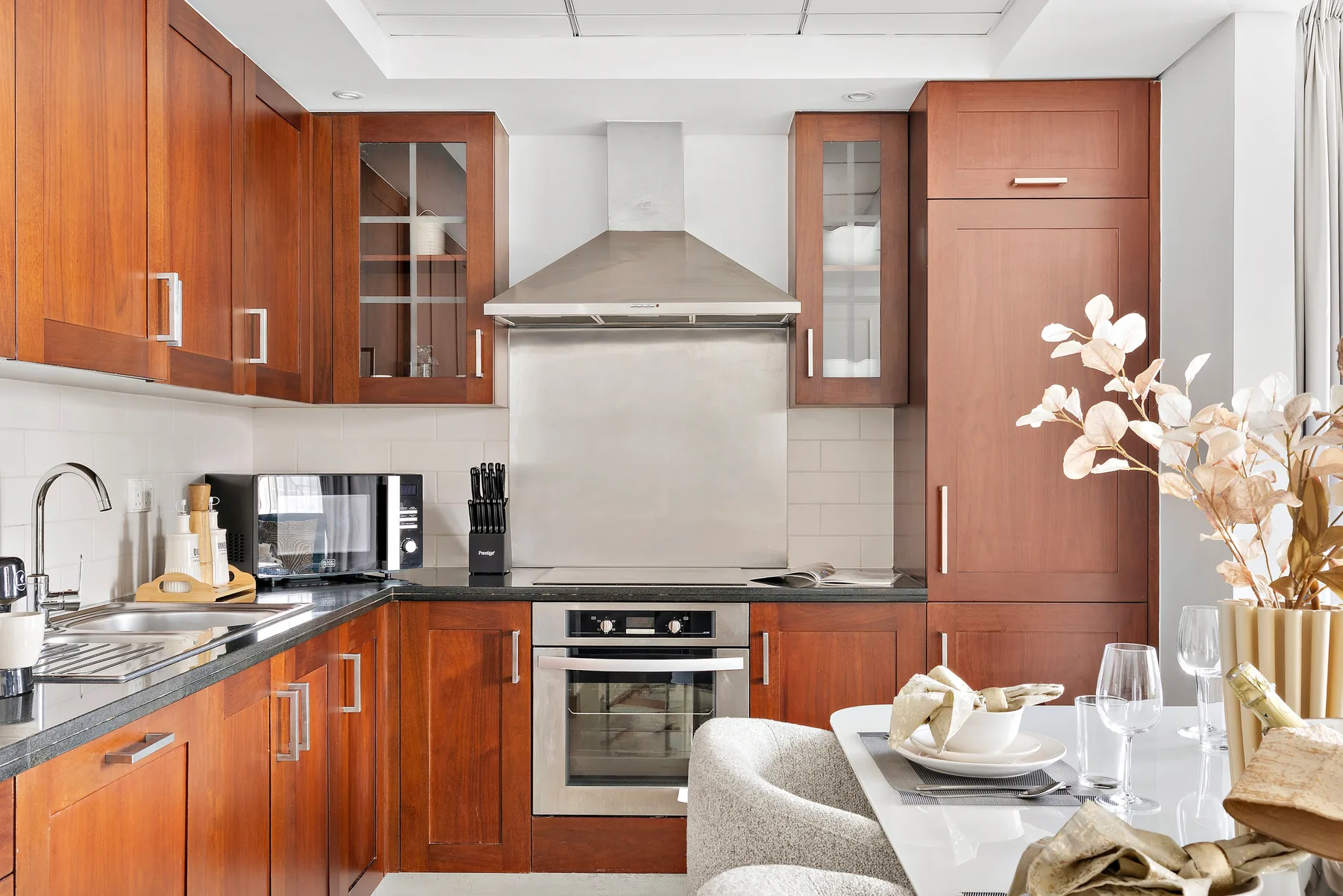 Una cocina moderna con armarios de madera y una mesa de comedor en primer plano.