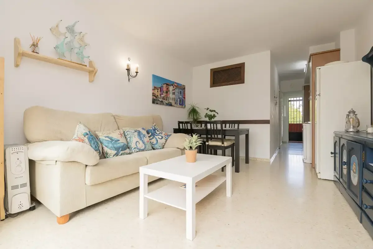 Living and dining area with a sofa, table, and white coffee table.