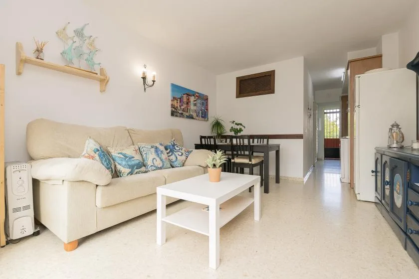 A living and dining area with a sofa, coffee table, and dining table.