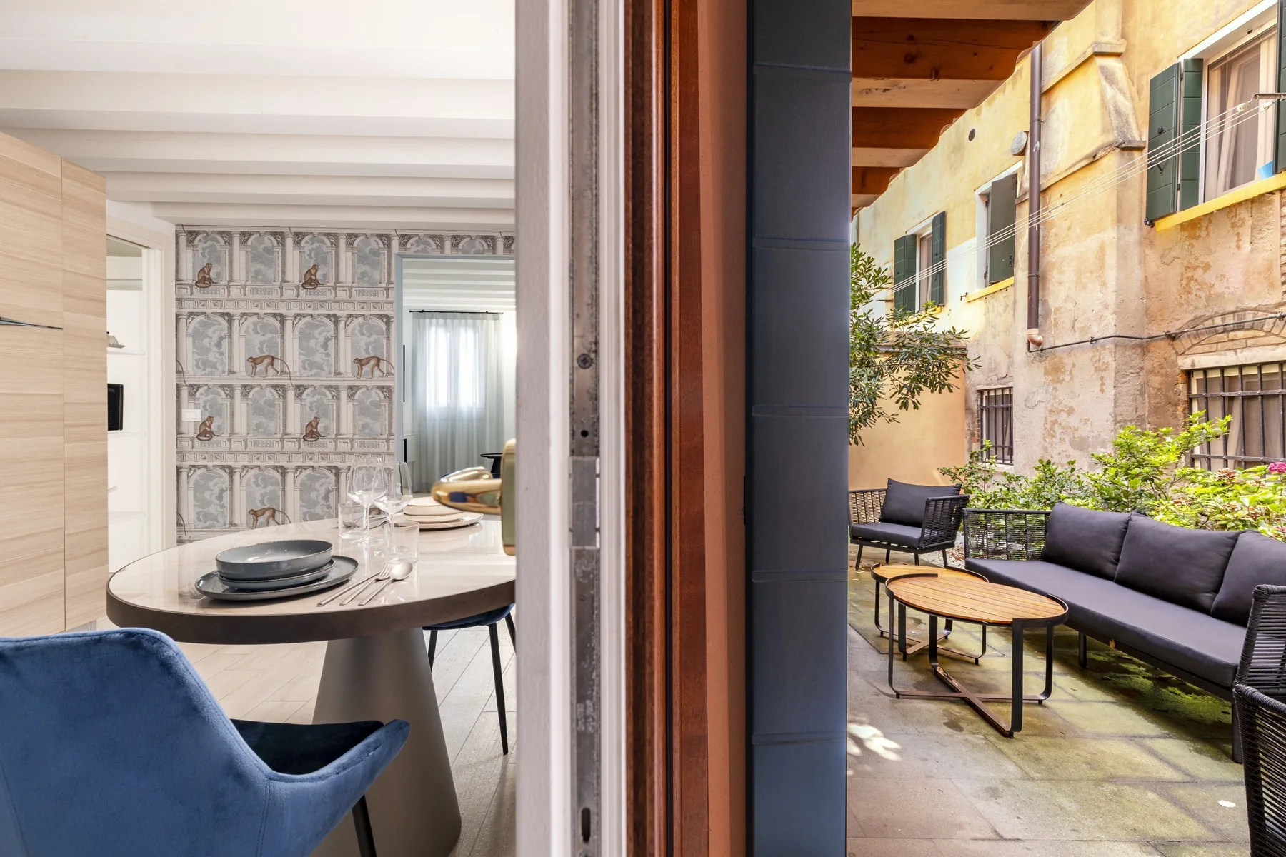 El comedor se abre a un patio exterior con asientos y una mesa.