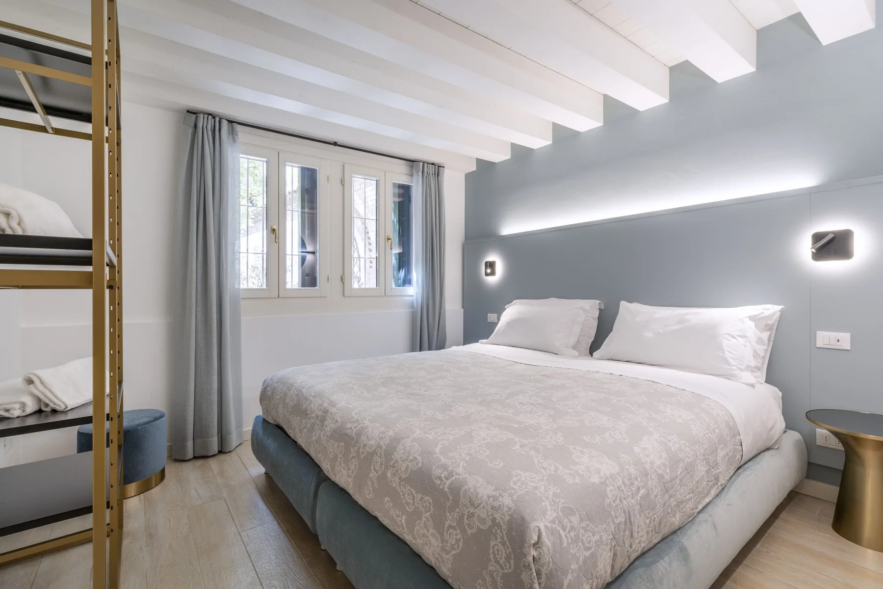 Un dormitorio con una cama grande, cortinas grises y una ventana.