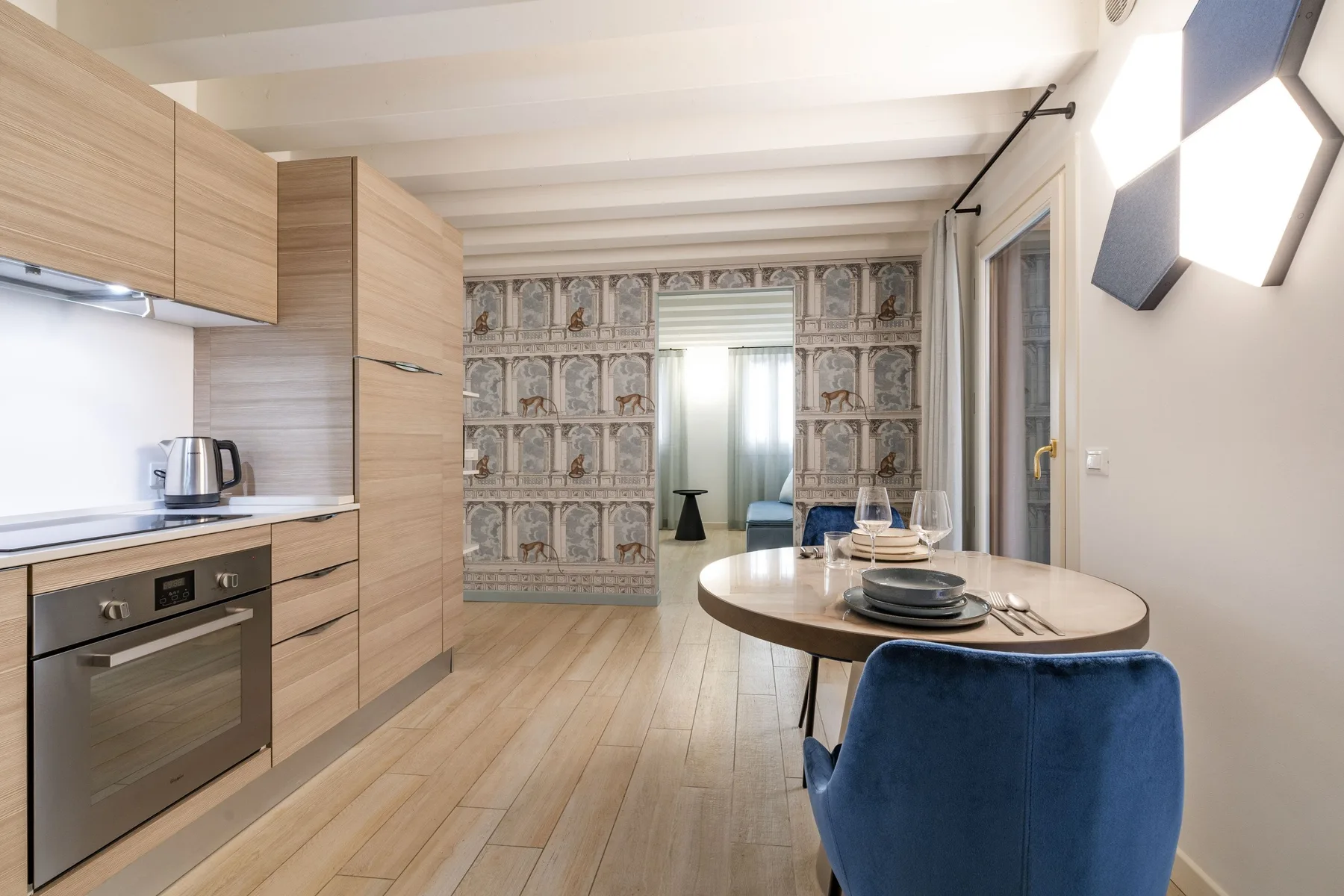 Una cocina compacta y zona de comedor con gabinetes de madera y una mesa redonda.