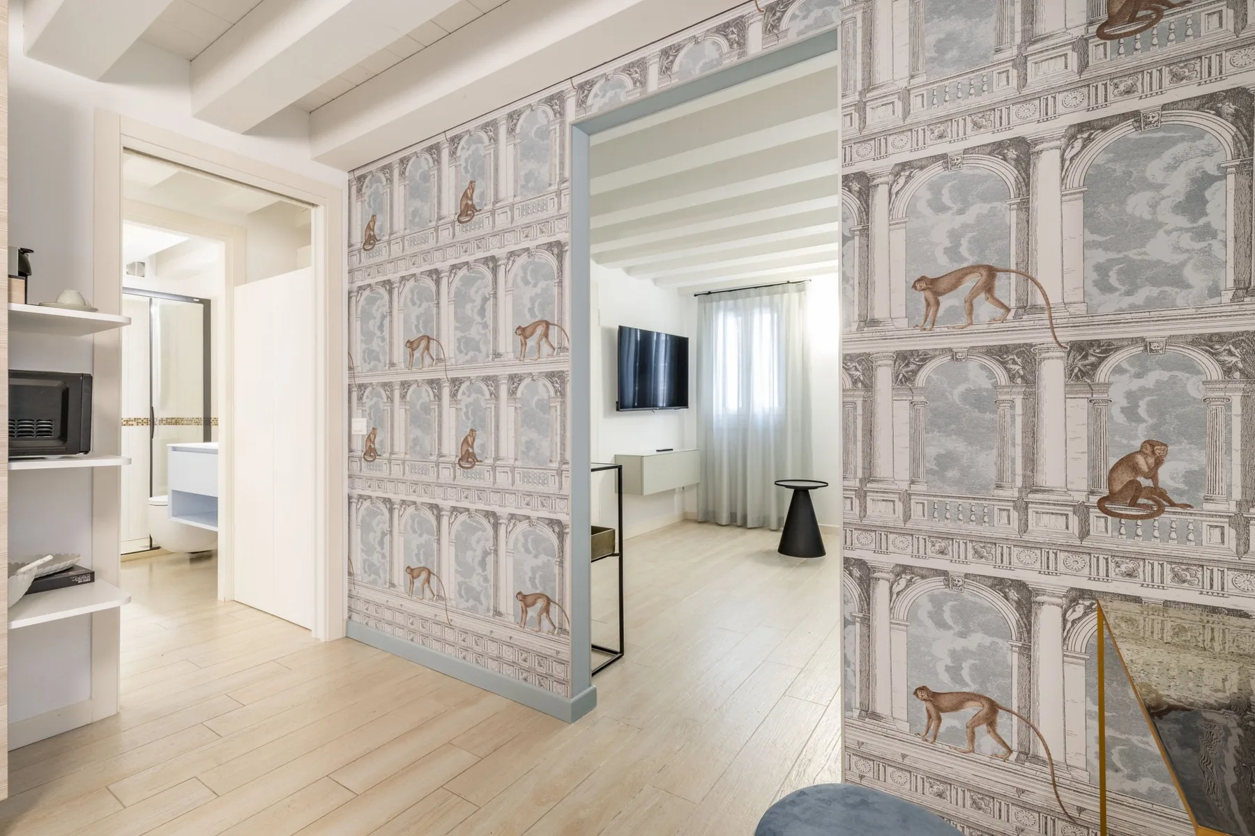 Una sala luminosa con paneles decorativos en las paredes, un televisor y suelo claro.