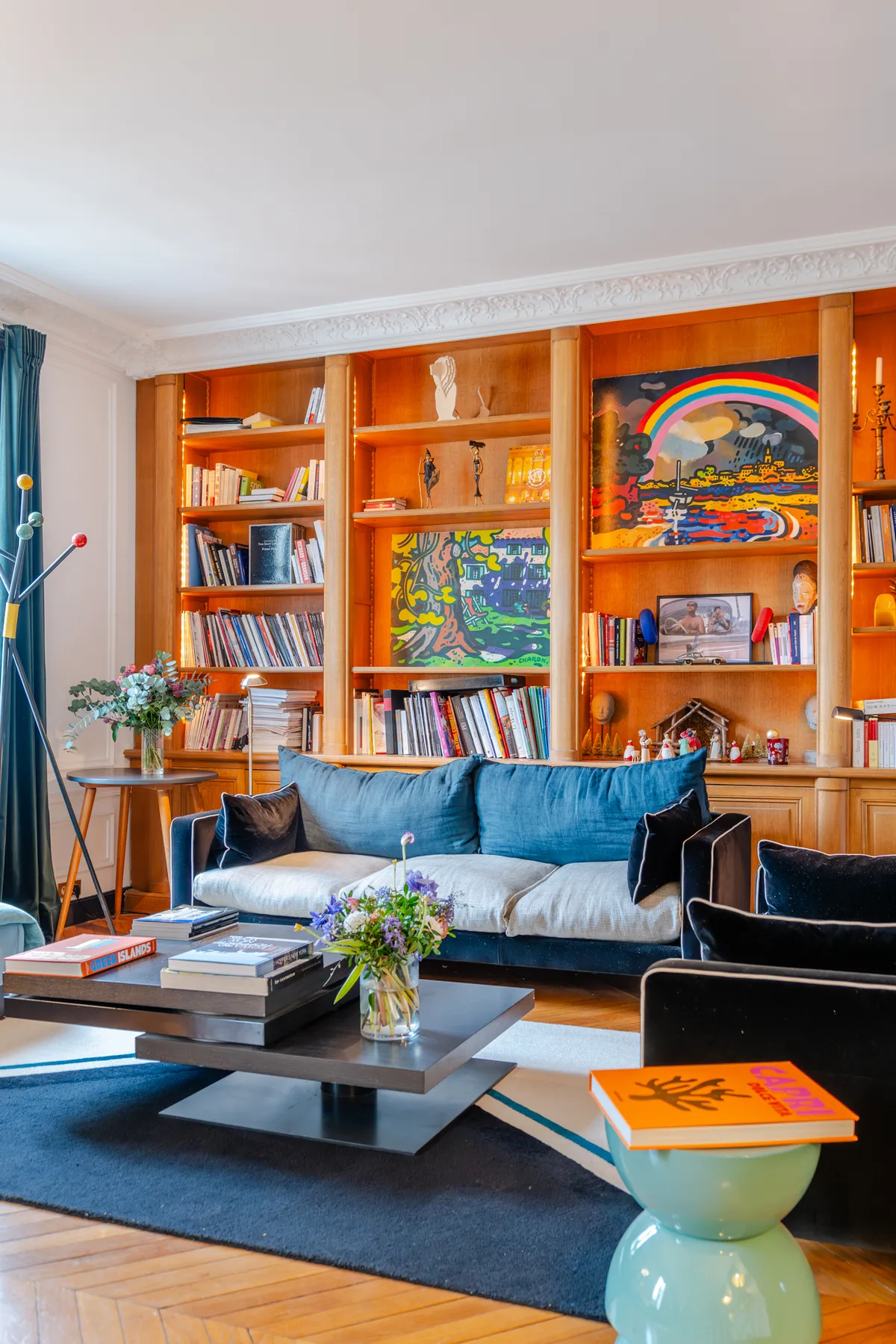 A living room with built-in bookshelves and a blue sofa.