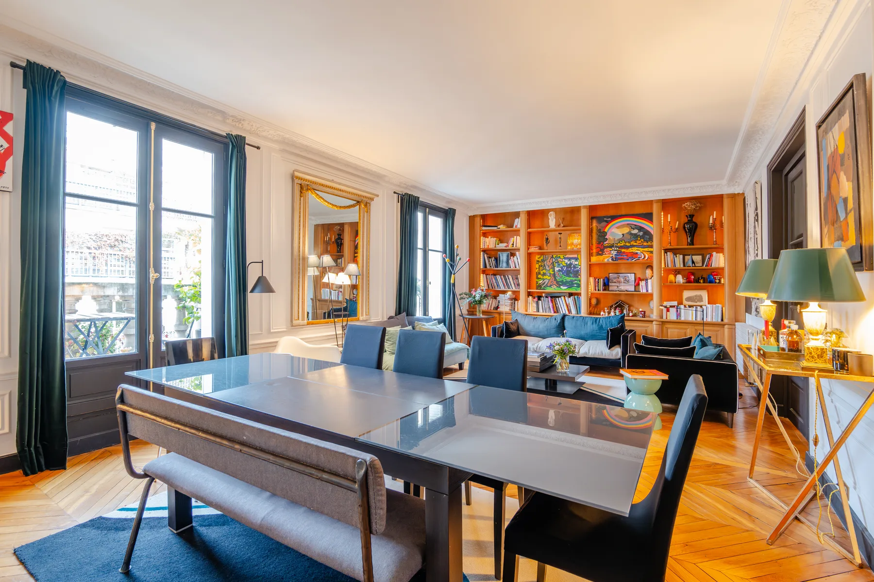Living room and dining area with a large table and bookshelves.