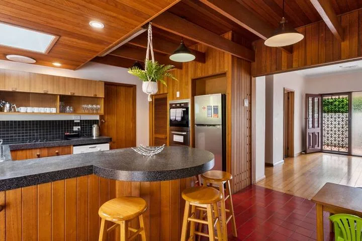 Una cocina revestida de madera con una barra curva y taburetes.