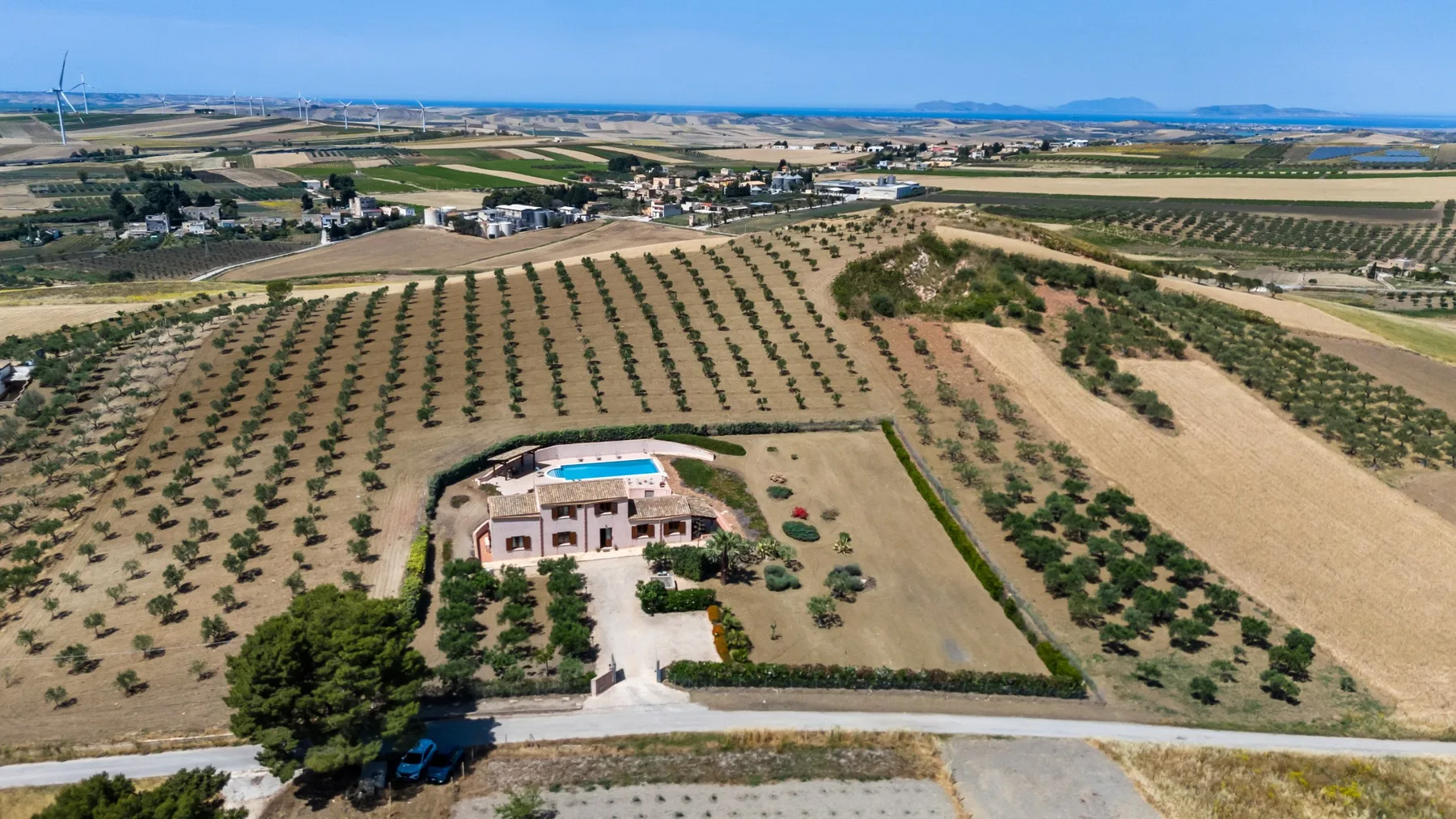 An aerial view of a countryside property surrounded by cultivated fields.