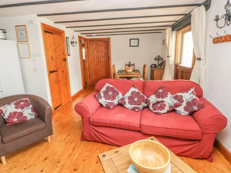 Una sala de estar con asientos rojos, una mesa de centro de madera y puertas de madera.