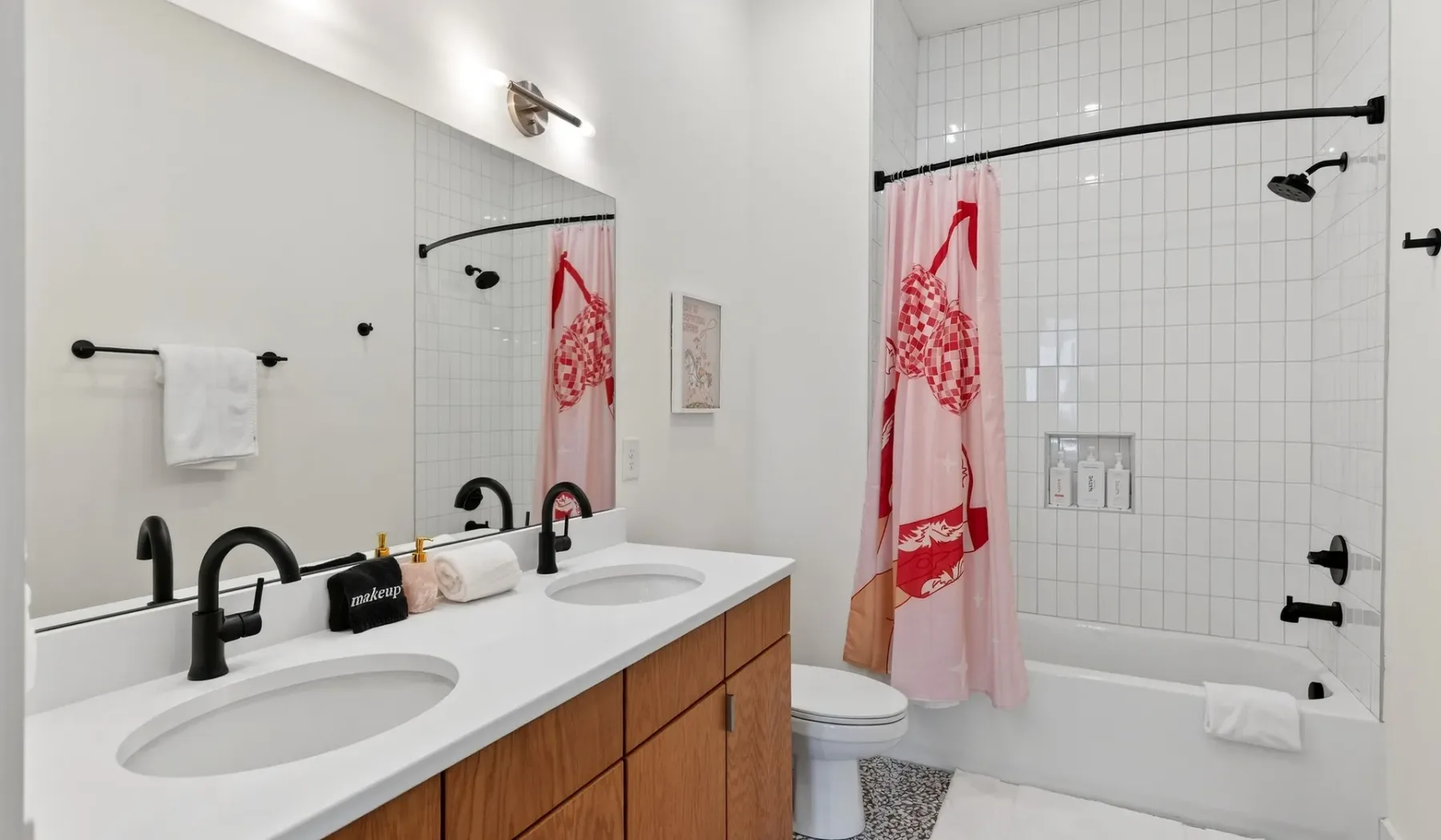 A bright bathroom with a double sink vanity and a bathtub.