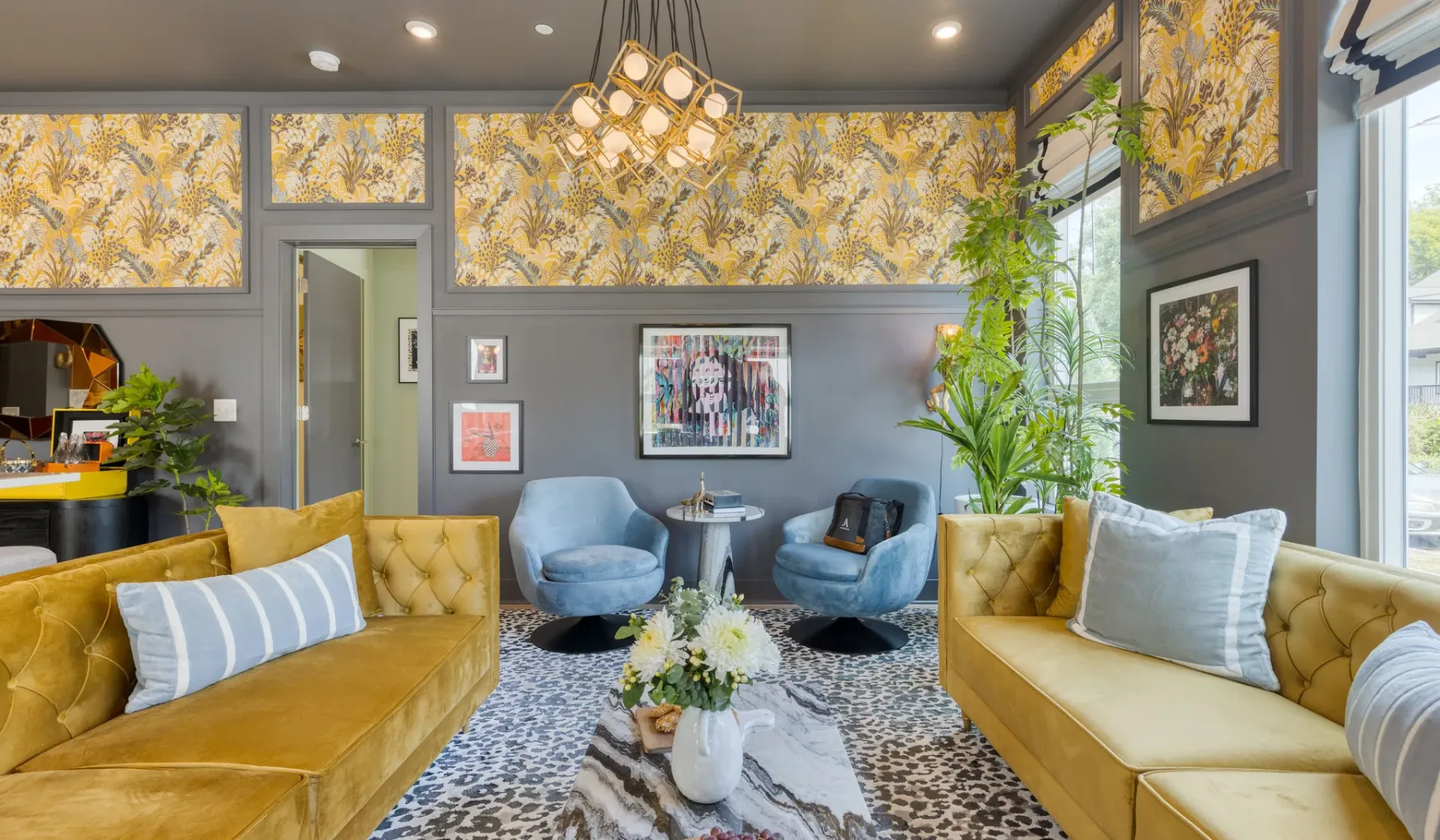 A colorful lounge with mustard seating, blue armchairs, and patterned wall panels.