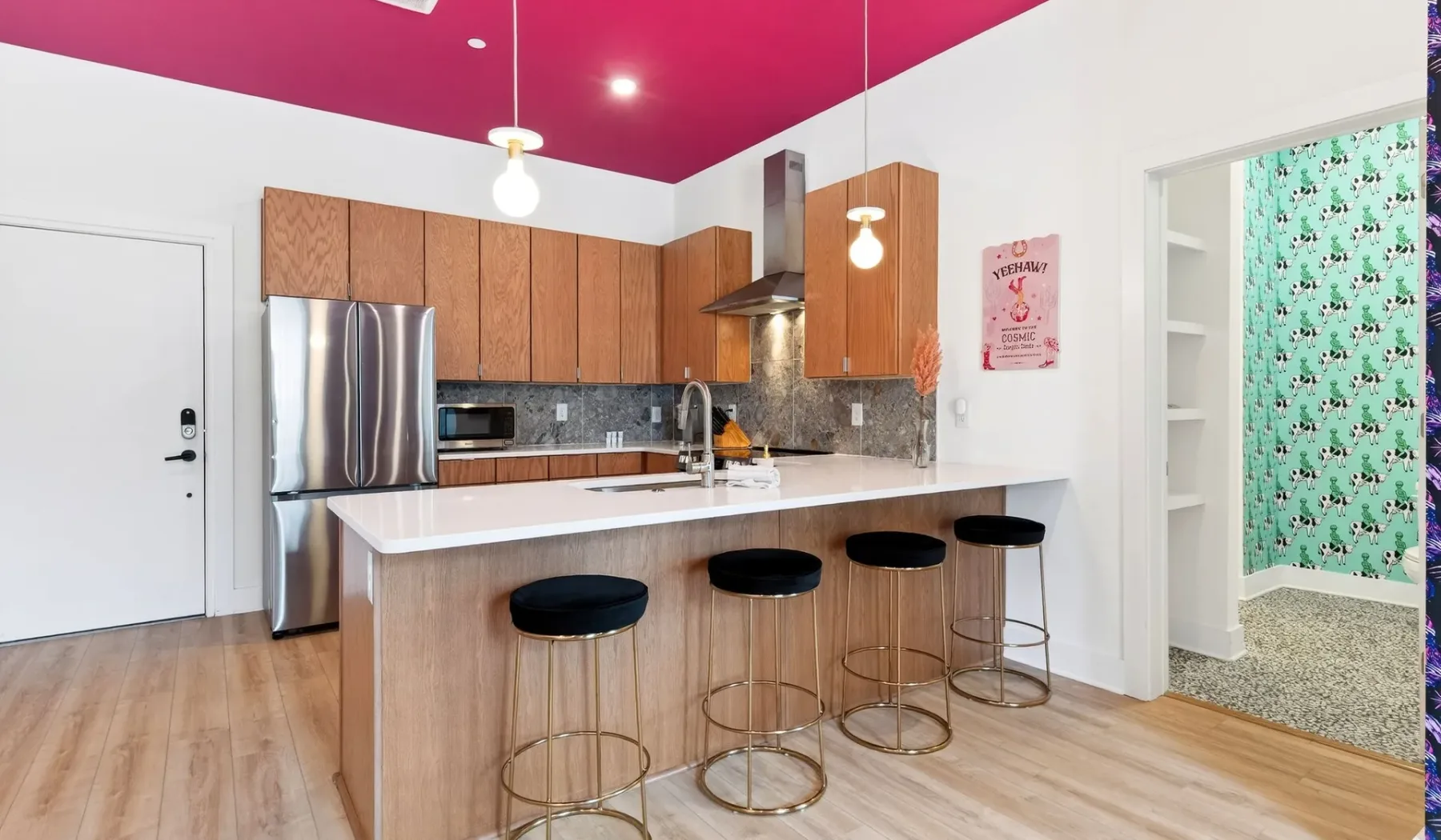 A bright kitchen with a large island, bar seating, and wood cabinetry.