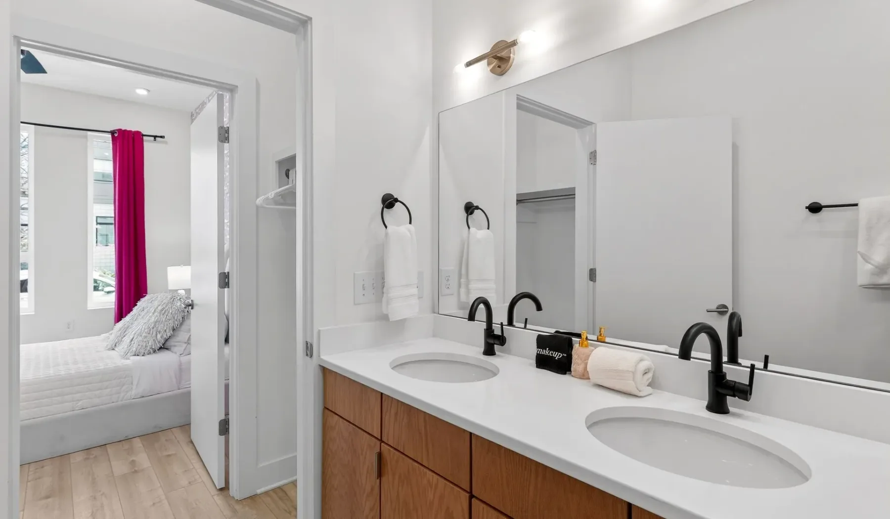 A bright bathroom with a double sink vanity and large mirror.