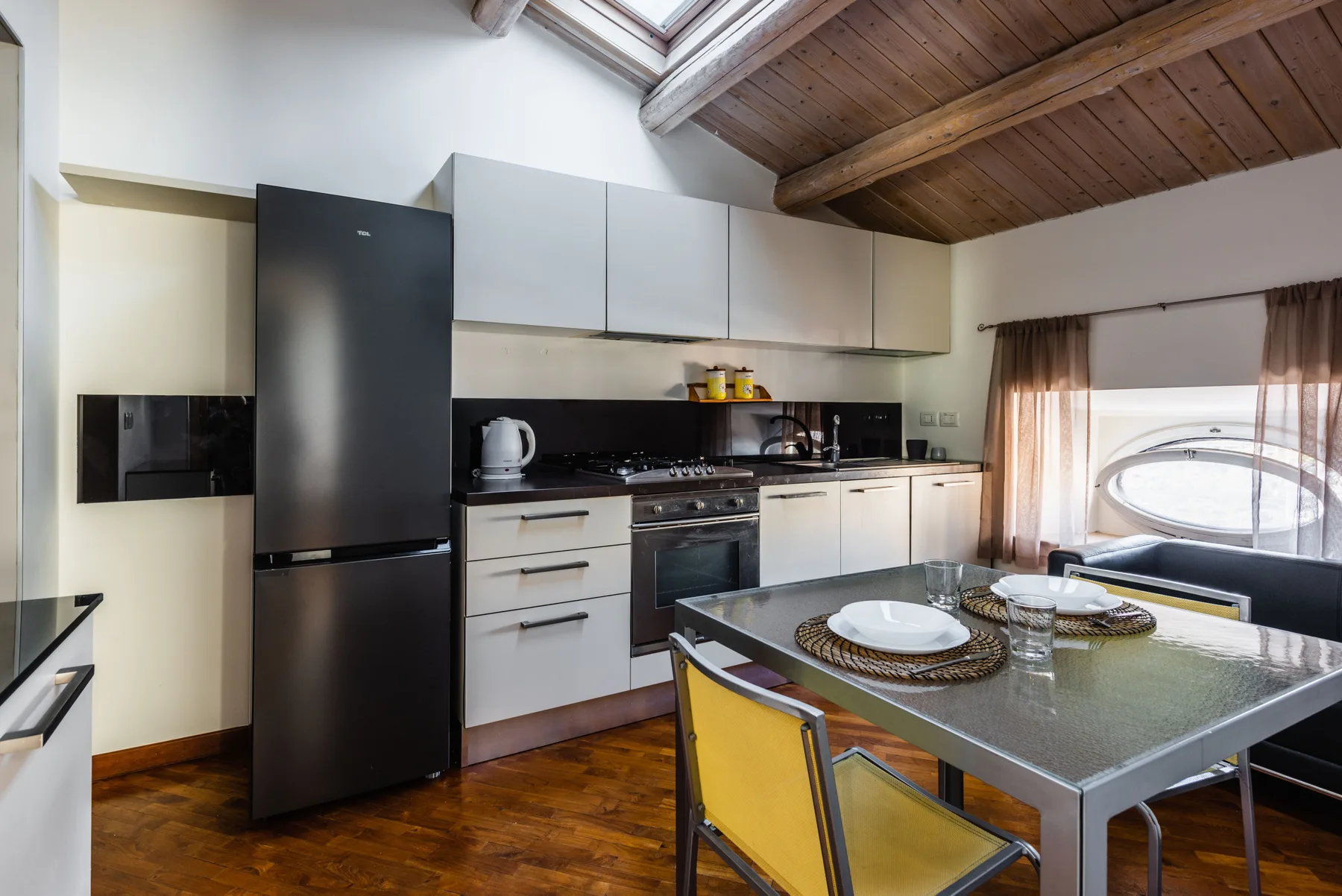 Una cocina y comedor con mesa, sillas y una claraboya.