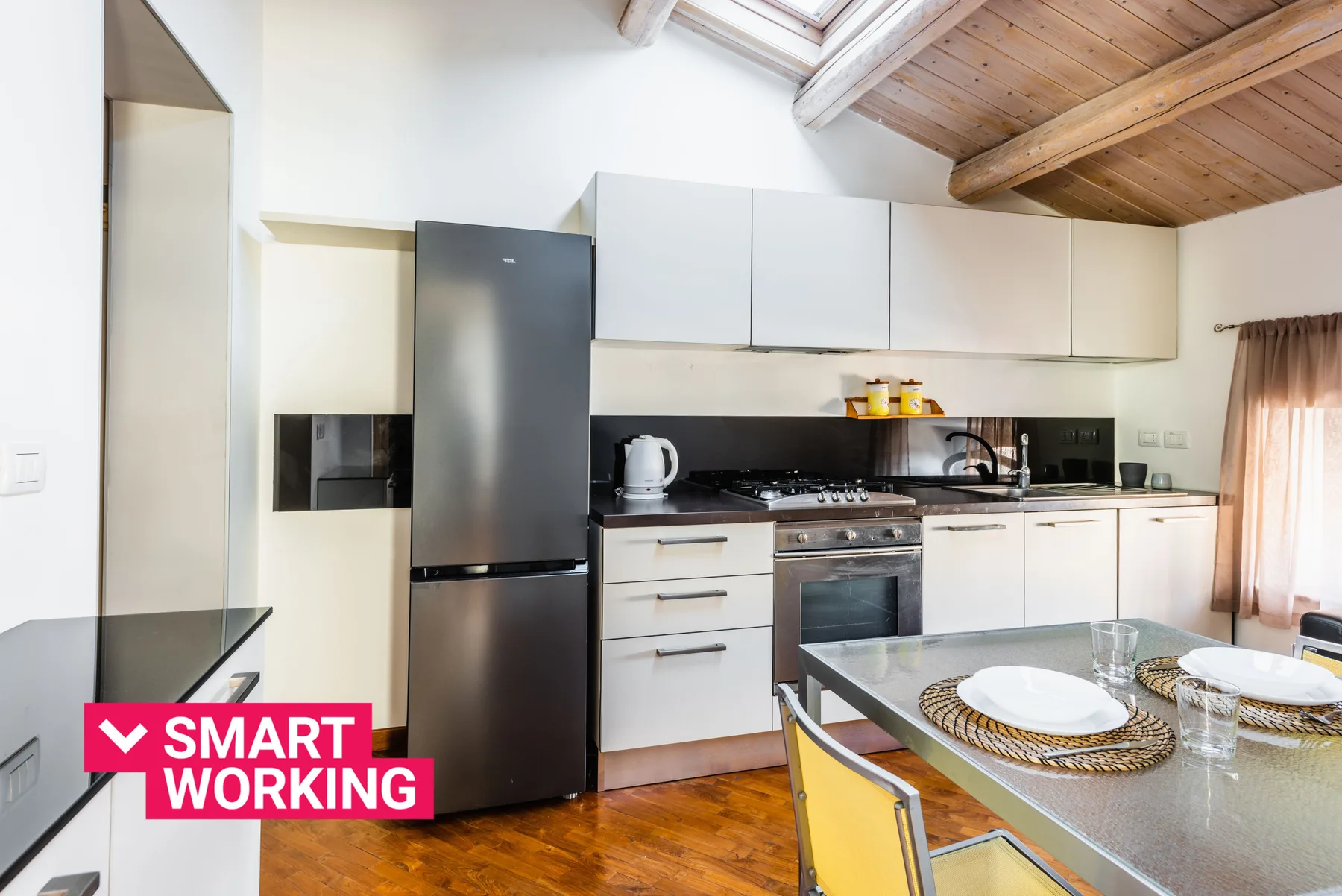 Una cocina luminosa con una mesa de comedor y techo de madera.