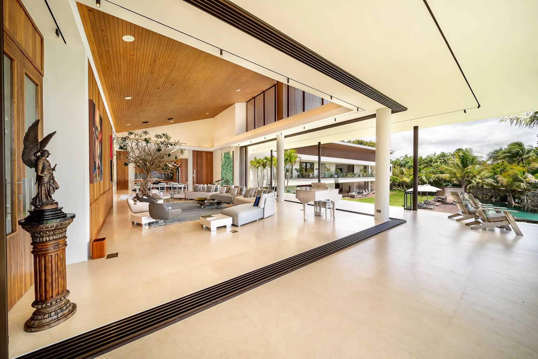 An open-plan living and dining area opens onto a patio with poolside seating.