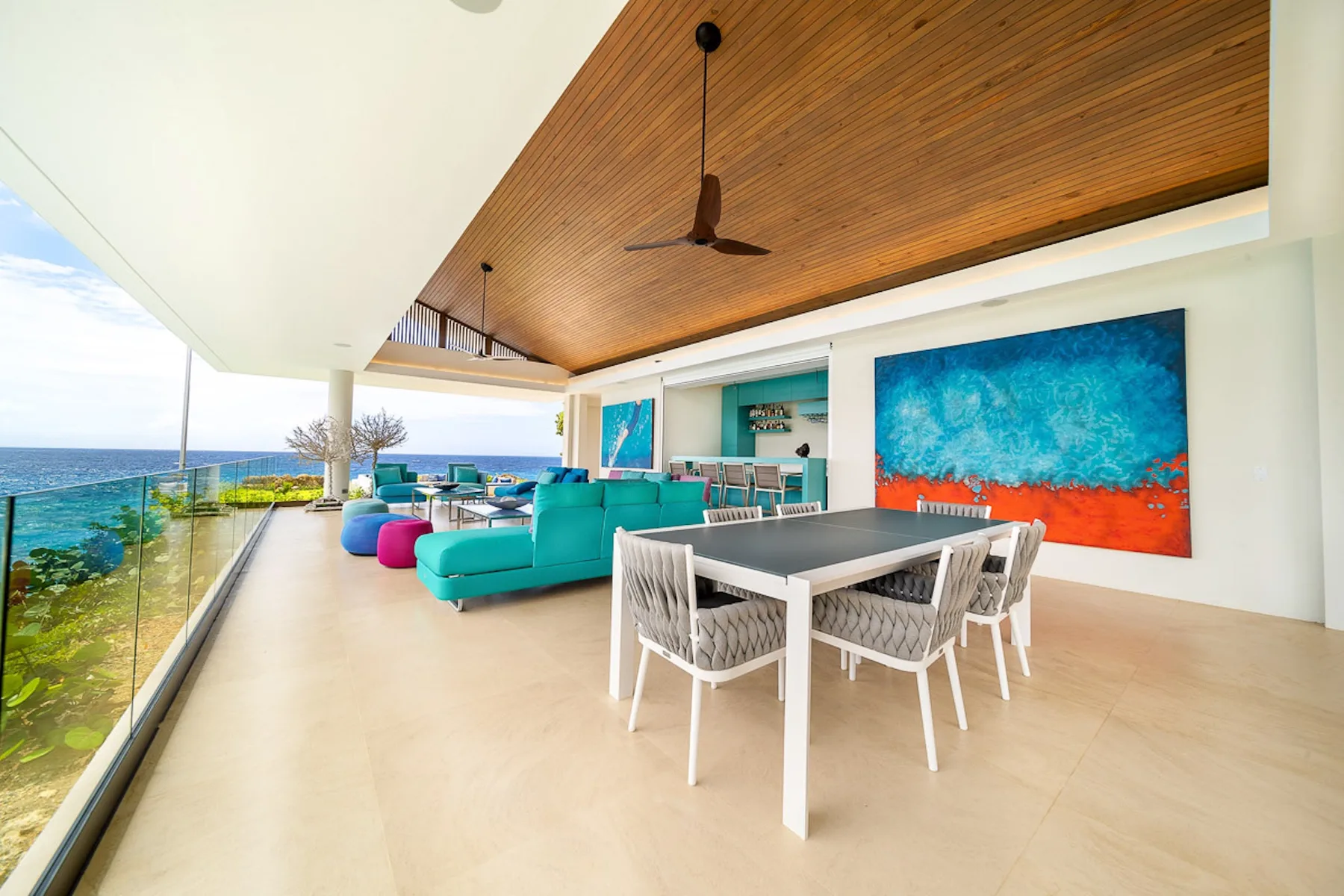 An open living and dining area with seating, a table, and ocean views.