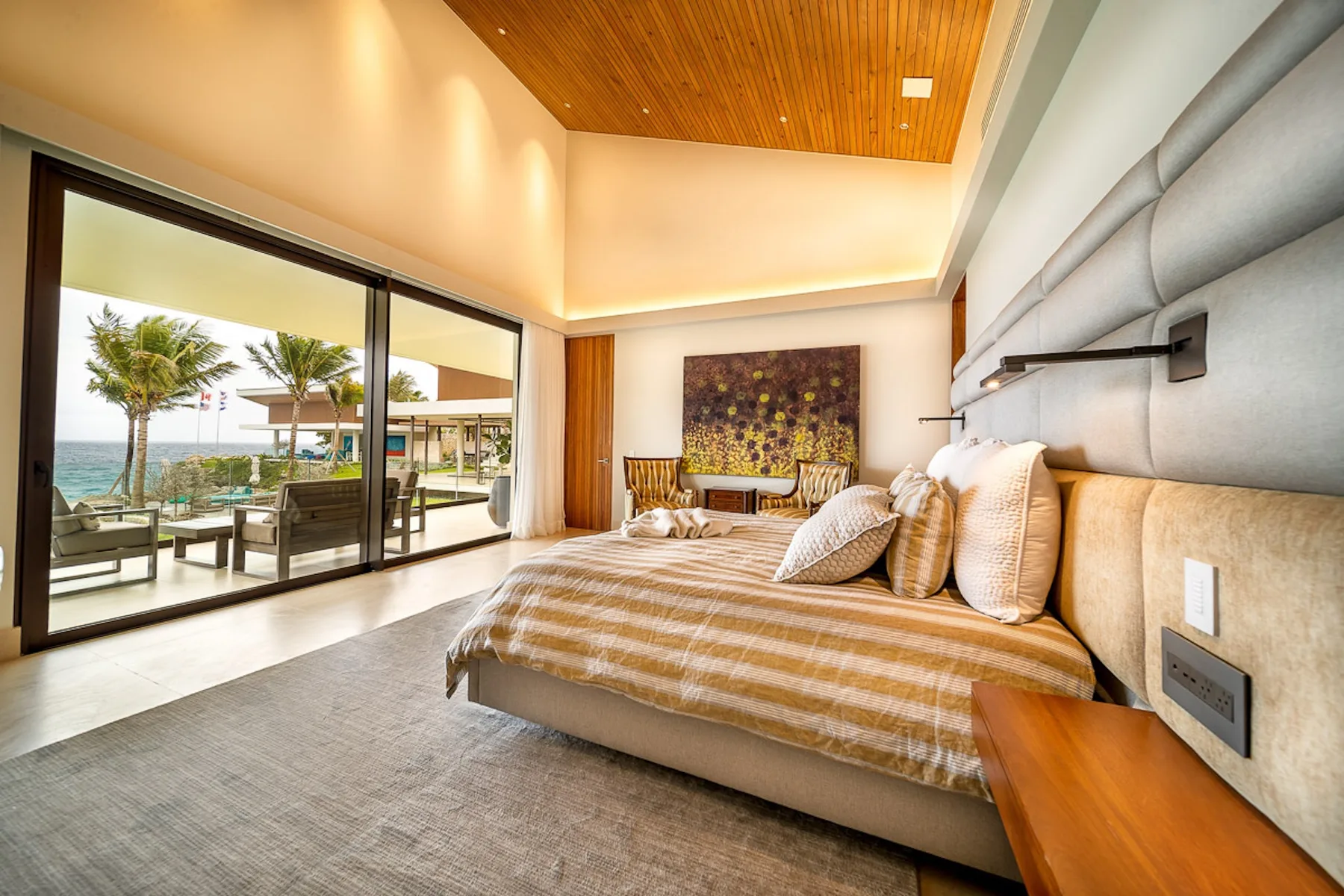 A bedroom with a large bed beside sliding glass doors opening onto a patio.