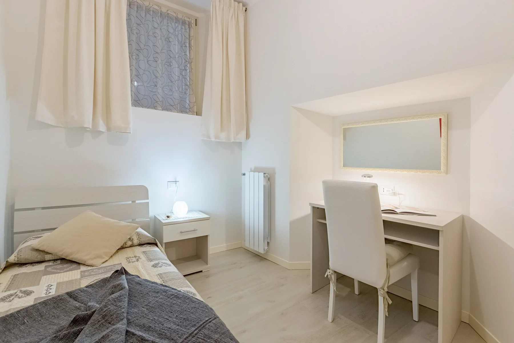 Un dormitorio con una cama individual junto a un escritorio y una silla.
