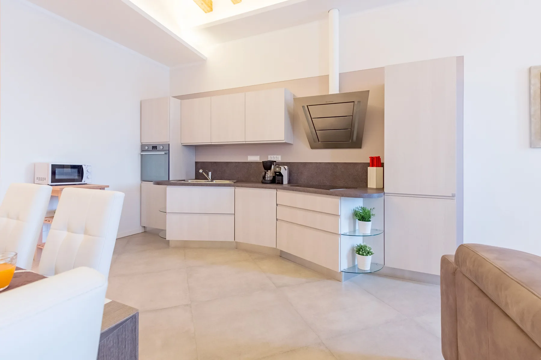 Una cocina luminosa con gabinetes claros y un comedor.