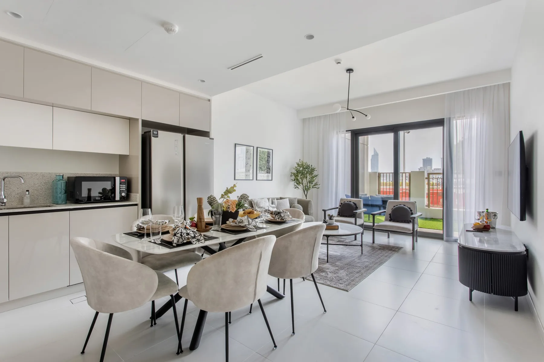 Una luminosa cocina-comedor de planta abierta con asientos junto a grandes ventanas.