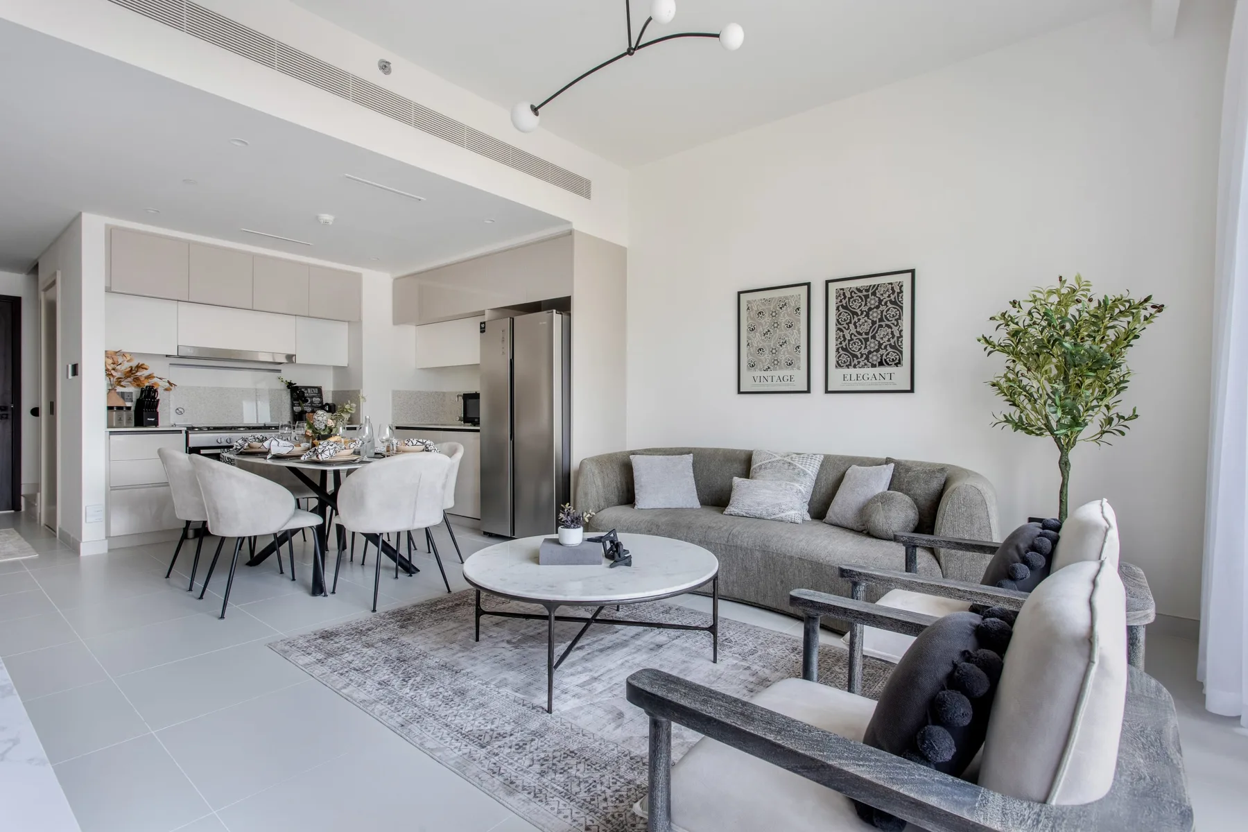 Una sala luminosa con comedor y cocina abierta.