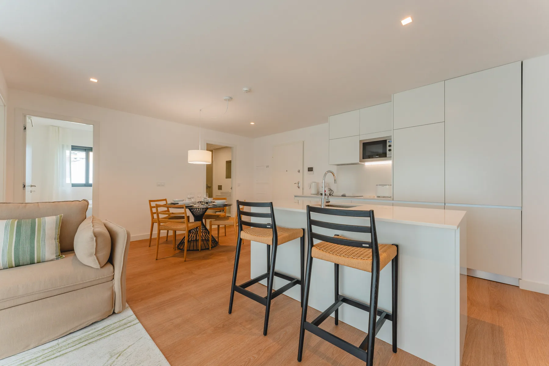 Una sala diáfana con comedor, una isla de cocina y asientos.