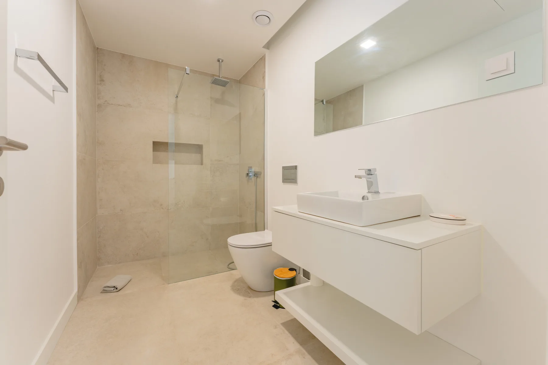 Un baño moderno con ducha, inodoro y tocador.
