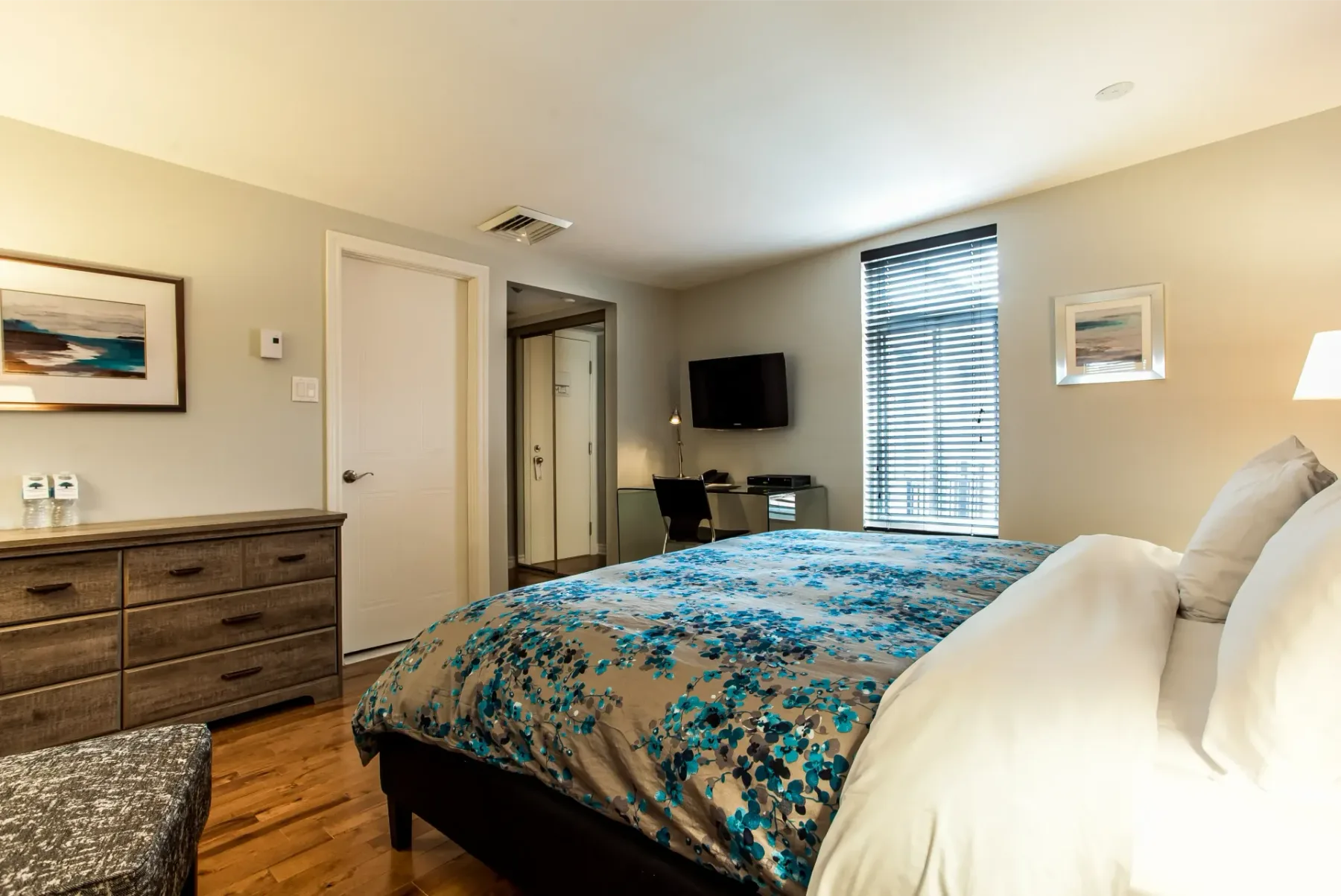 A room with a king-size bed and dresser.