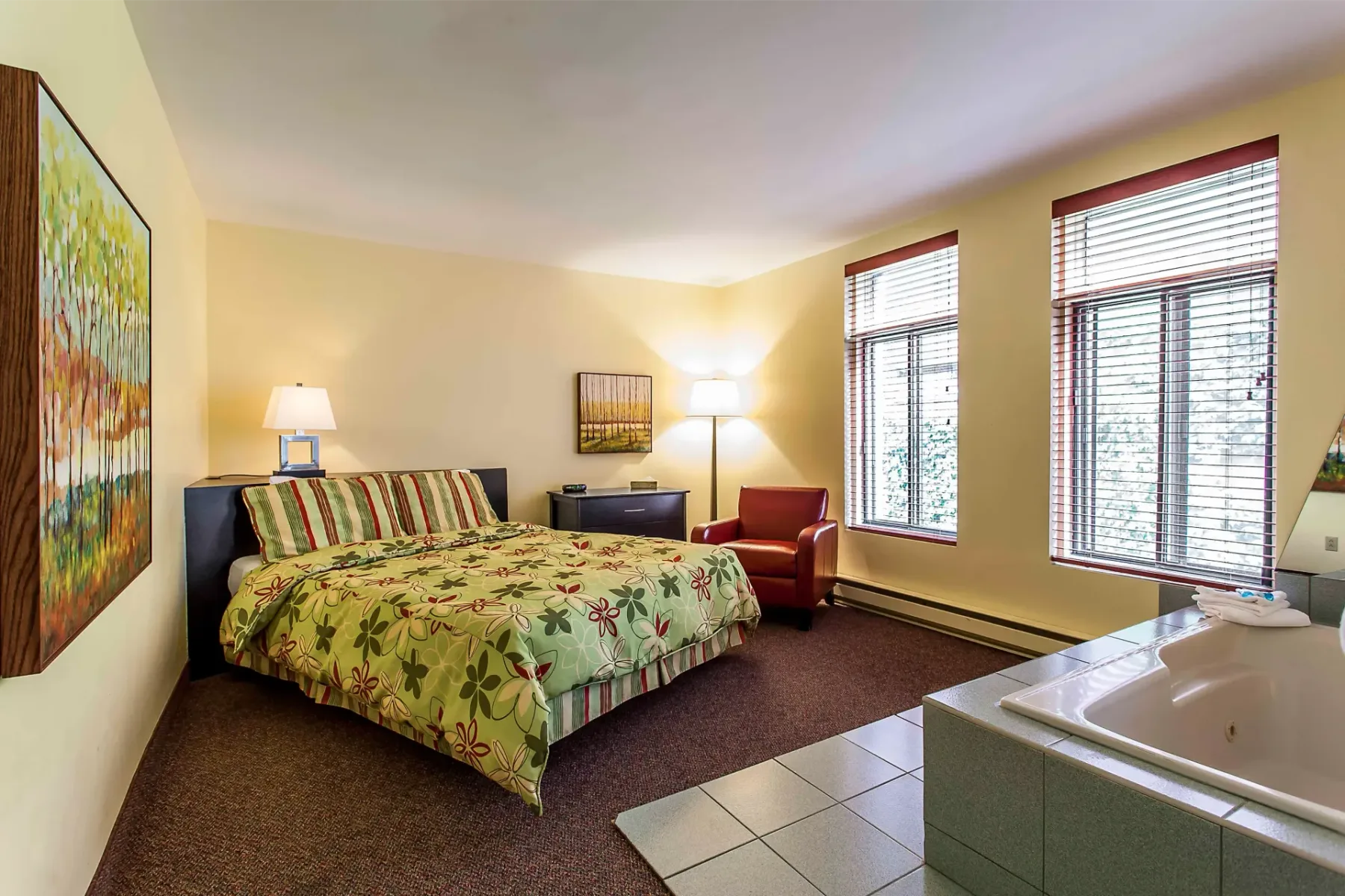 A hotel room with a king-size bed and jacuzzi.