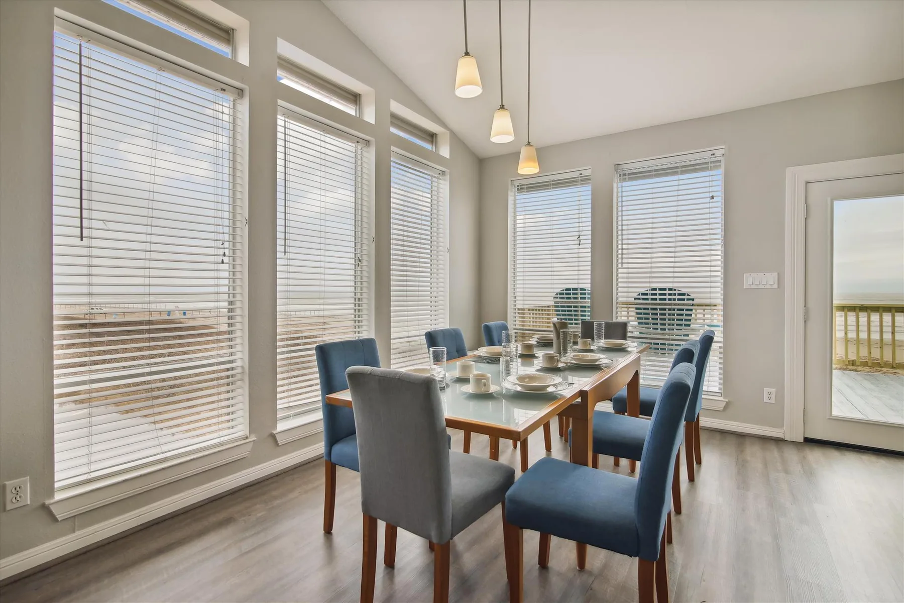 A bright dining area with a long table and large windows.