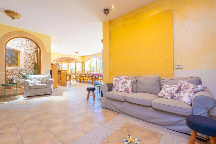 A living room with seating and a dining area visible in the background.