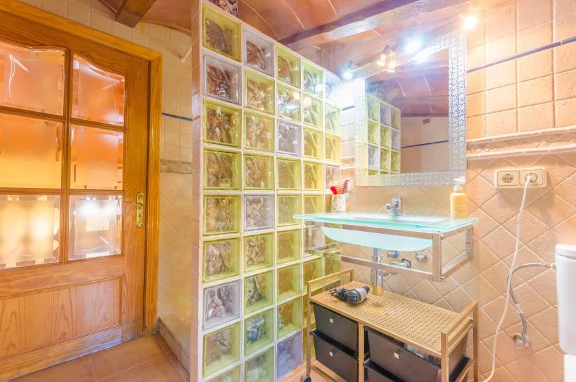 A warm-toned bathroom with a glass-block partition and sink.