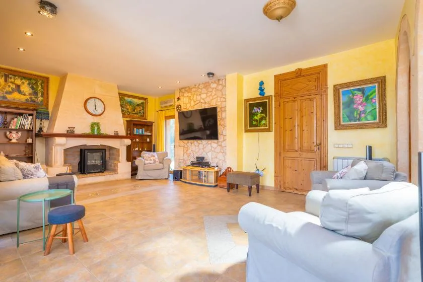 Living room with seating arranged around a fireplace and television.