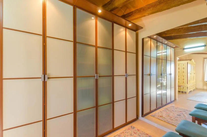 A room with wood-framed sliding panels and seating beside a rug.