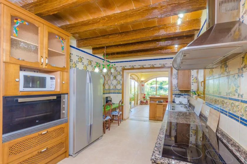 A kitchen with wooden cabinets and appliances along both sides.