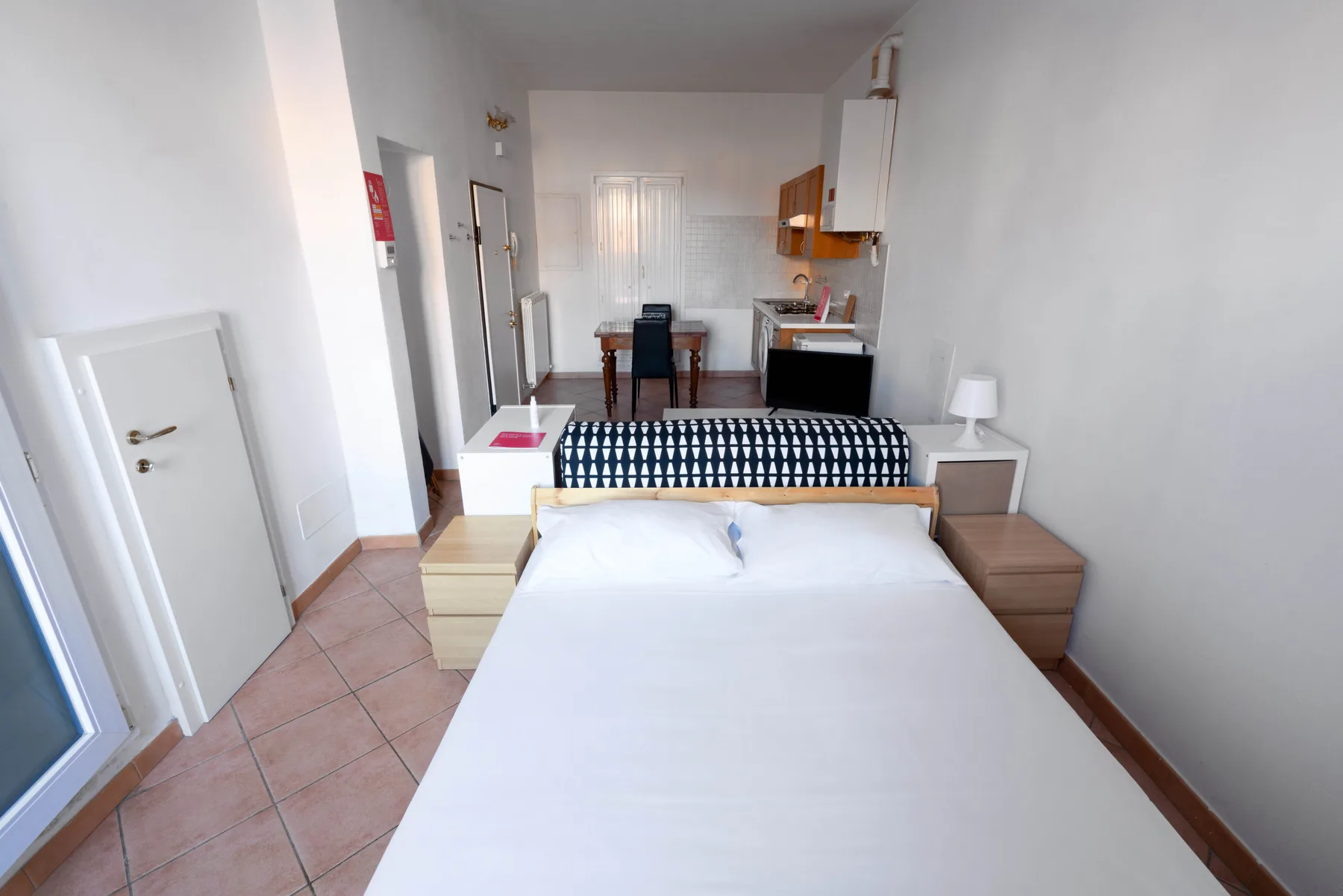 Un dormitorio con una cama grande, un cabecero estampado y un escritorio pequeño.