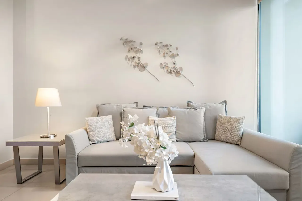 Una sala luminosa con asientos seccionales y adornos florales en la pared.