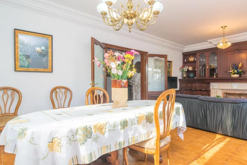 A dining room with a flower arrangement on the table and wooden cabinetry in the background.