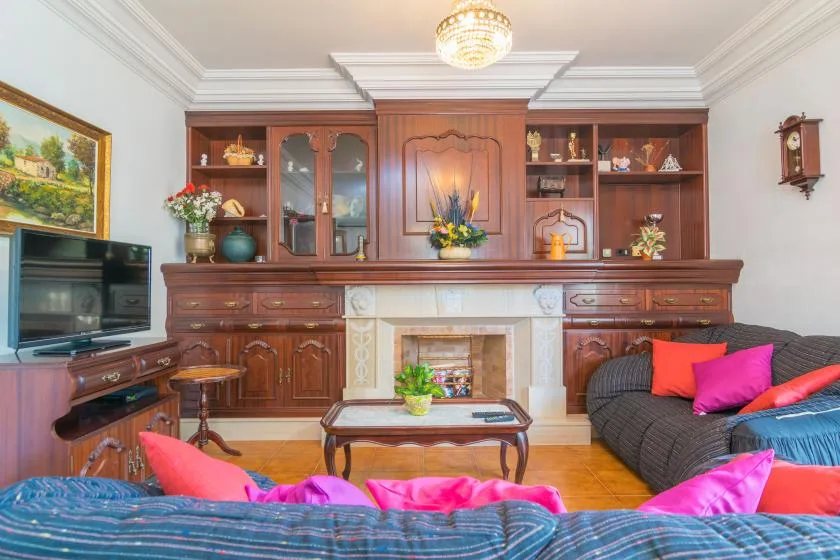 A living room with a fireplace, wooden cabinetry, and seating.
